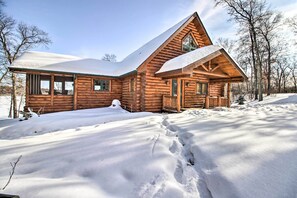 A log cabin with a snow-covered roof and a large front porch. - Stunning Crosslake Cabin w/ Deck and Lake Views! (Crosslake)