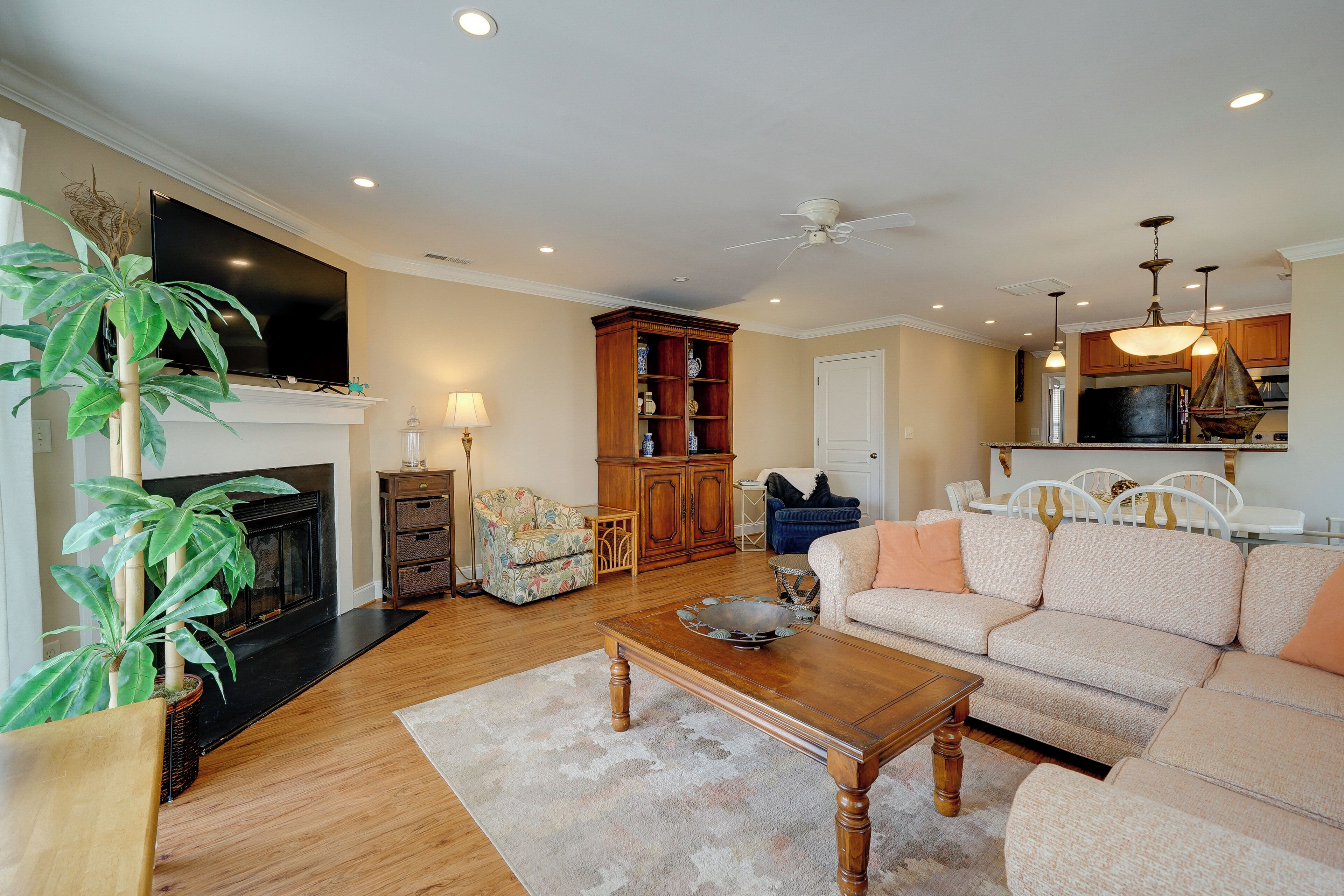 A living room with a fireplace, sofa, coffee table, and a television.