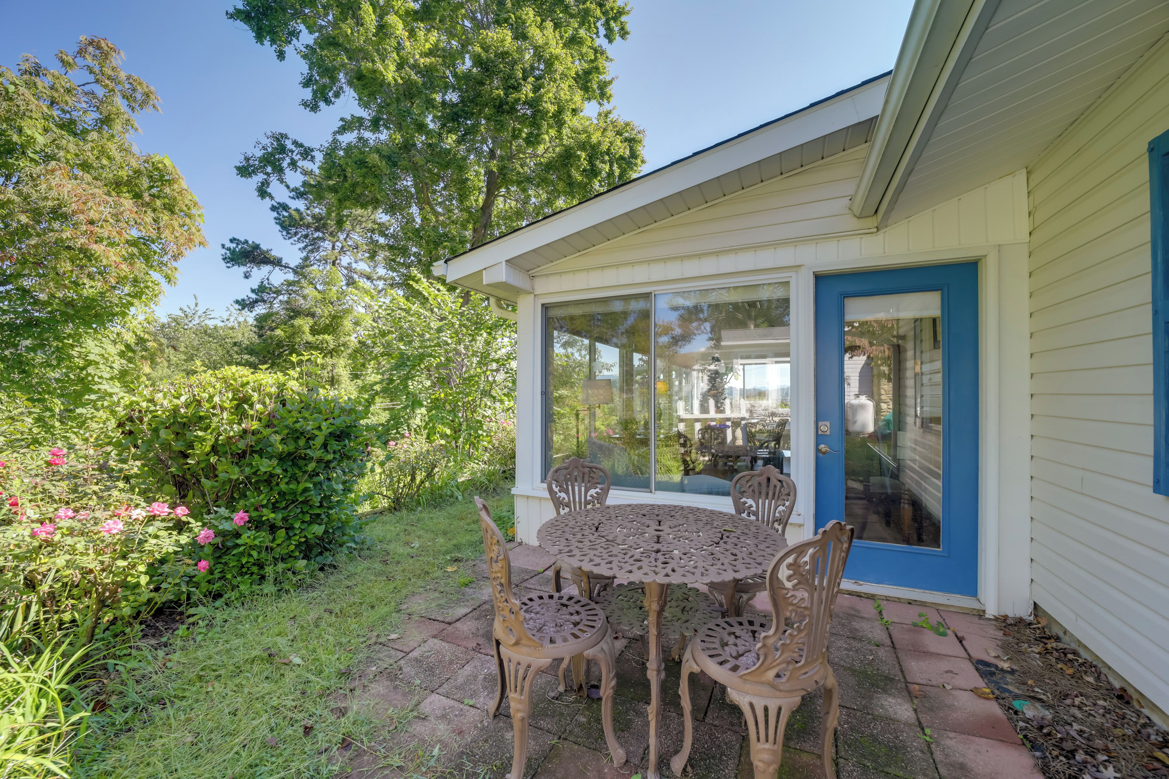 A patio with a round table and chairs, a glass door, and a view of the interior.