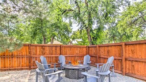 A backyard with a wooden fence, a fire pit, and four Adirondack chairs. - Historic Redstone w/ Large Backyard, Walk To Csu! (Fort Collins)