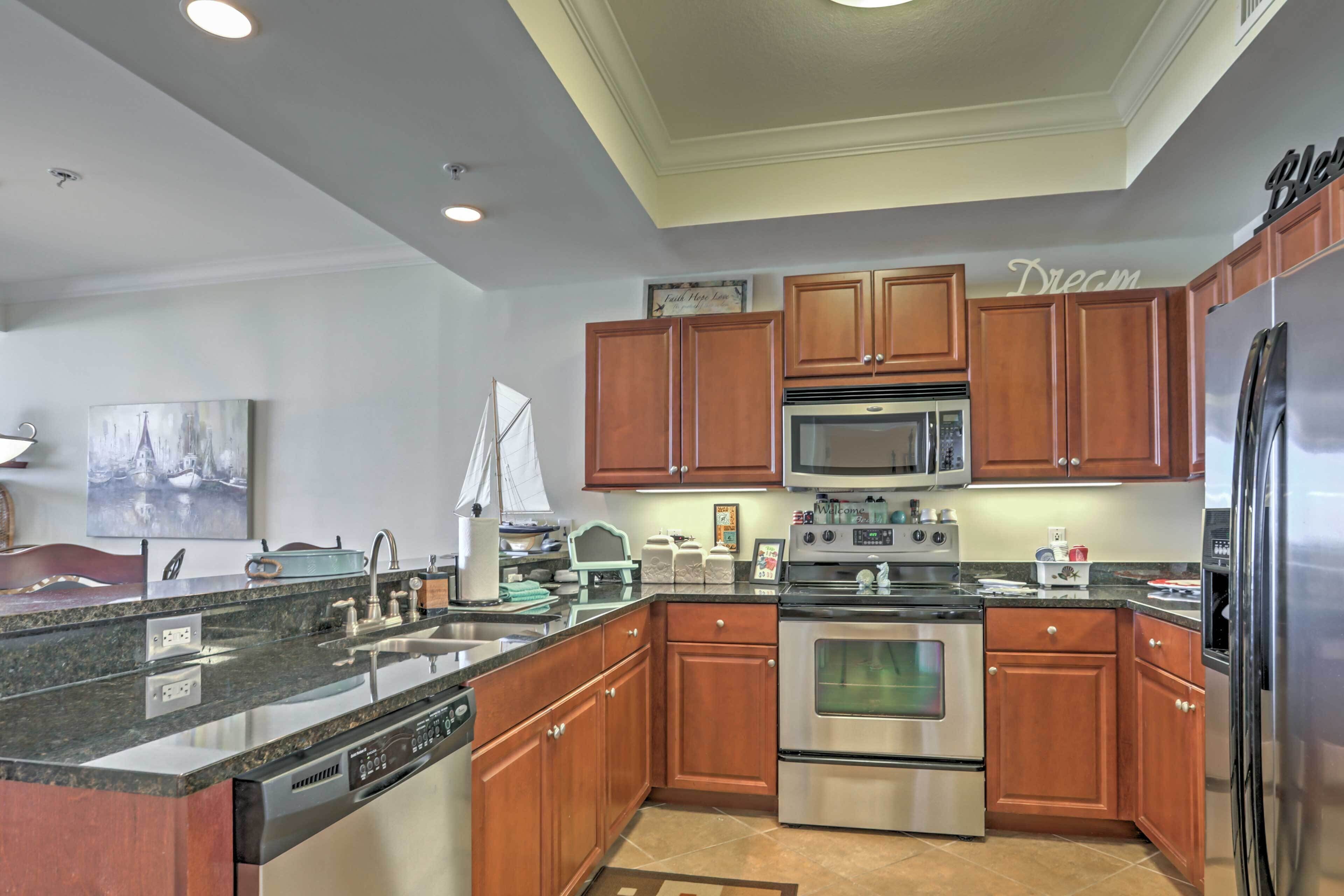 A modern kitchen with wooden cabinets, stainless steel appliances, and a granite countertop.