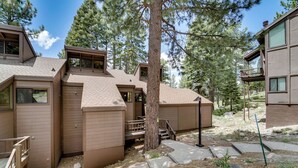A modern multi-story building with a wooden exterior, a central staircase, and a surrounding natural landscape. - 1 Mi to Northstar Skiing/snowboarding: Cozy Condo (Truckee)