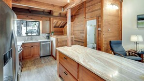 A modern kitchen with wooden cabinetry, a marble countertop, and a built-in dishwasher. - 1 Mi to Northstar Skiing/snowboarding: Cozy Condo (Truckee)