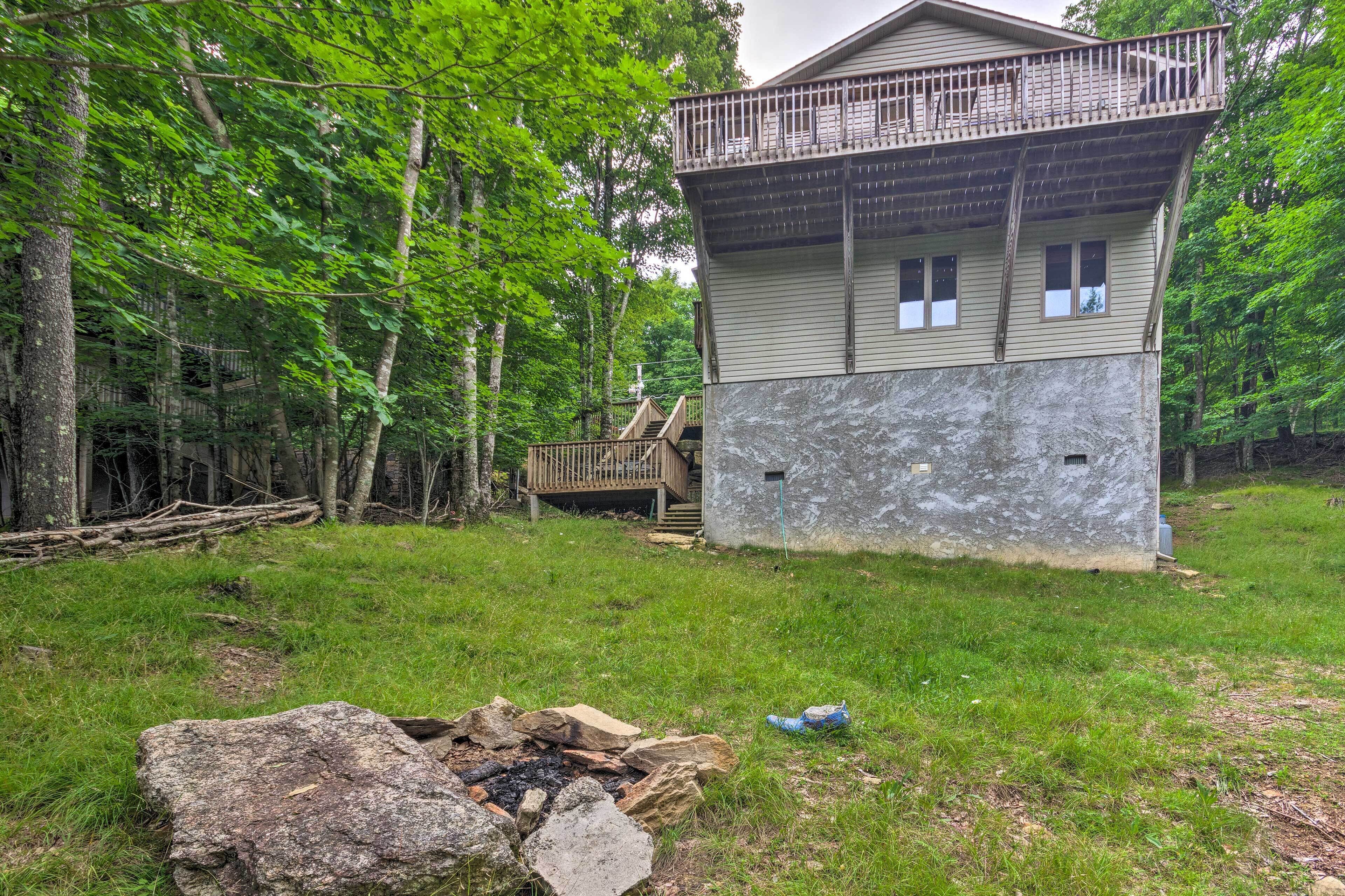 A cabin with a balcony, surrounded by trees.