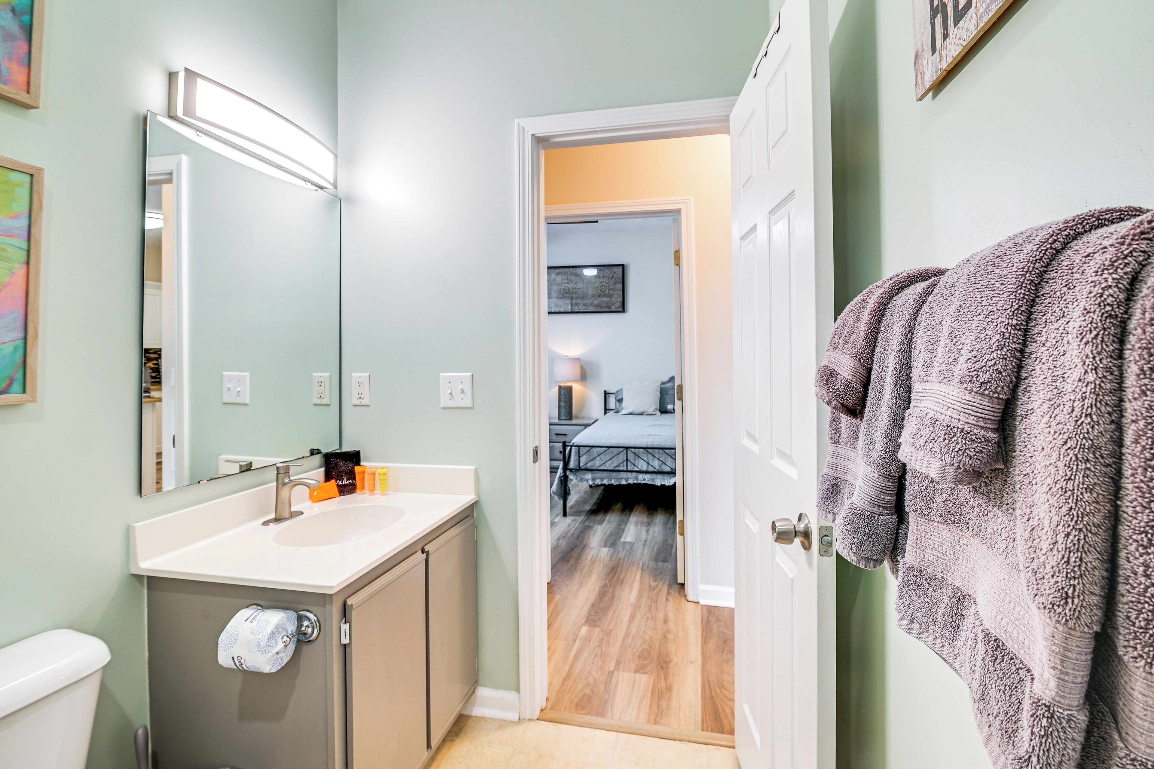 A bathroom with a sink, mirror, and towel rack.