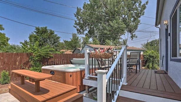 A wooden deck with a hot tub, a picnic table, and a small outdoor seating area. - Rapid City Home w/ Patio by Canyon Lake Park! (Rapid City)