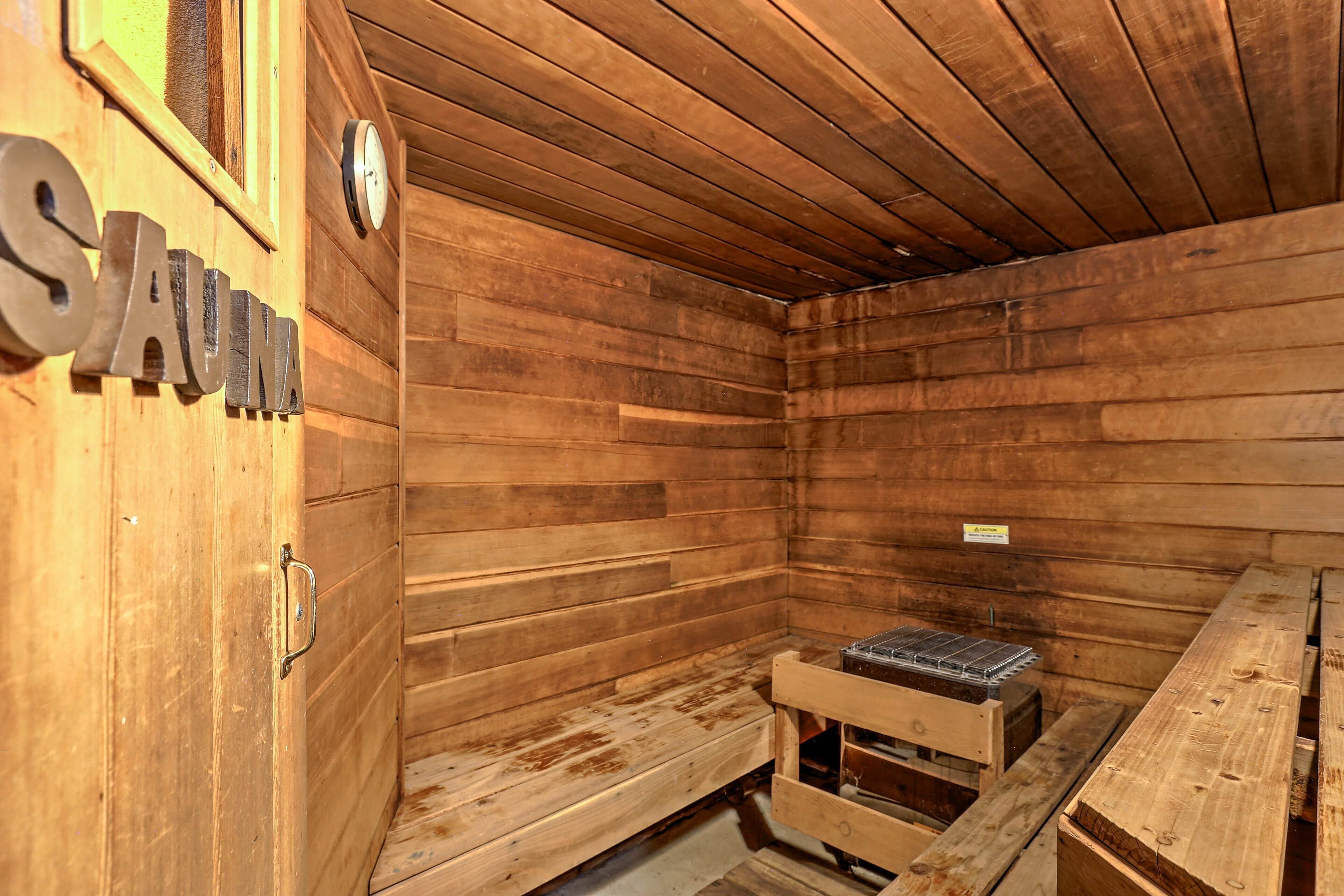 A sauna room with wooden walls and a bench.