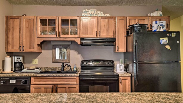 A kitchen with wooden cabinets, a black stove, a refrigerator, and granite countertops. - Angel Fire Mtn Escape: Walk to Chile Express Lift! (Angel Fire)