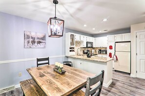 A modern kitchen with white cabinets, a granite countertop, and a built-in microwave.