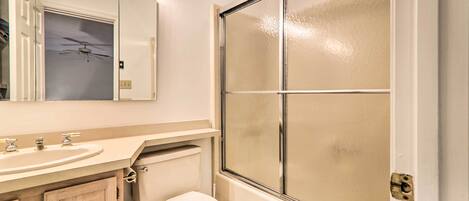A bathroom with a white sink, mirror, and toilet.
