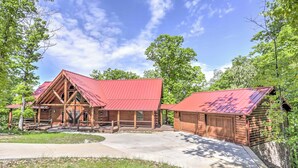 A log cabin with a red roof, a front porch, and a garage. - Private Eureka Springs Cabin w/ Beaver Lake Views! (Eureka Springs)