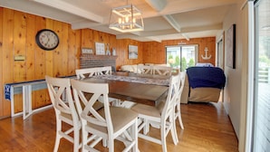 A dining area with a wooden wall, a clock, and a chandelier. - The Swedish Fish: Getaway on Lake Saint Clair! (Olympia)