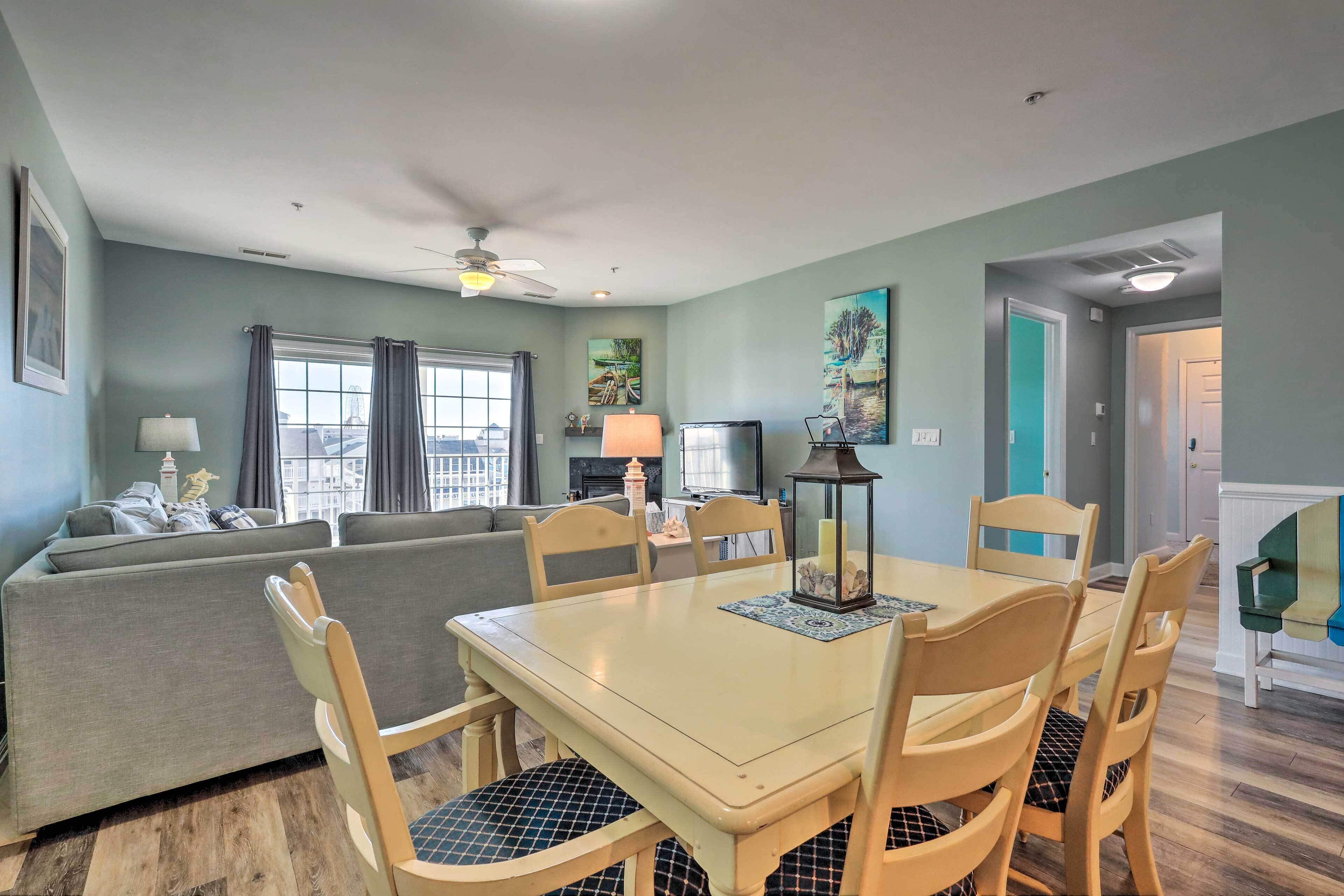 A dining area with a table and chairs, a sofa, and a television in the background.