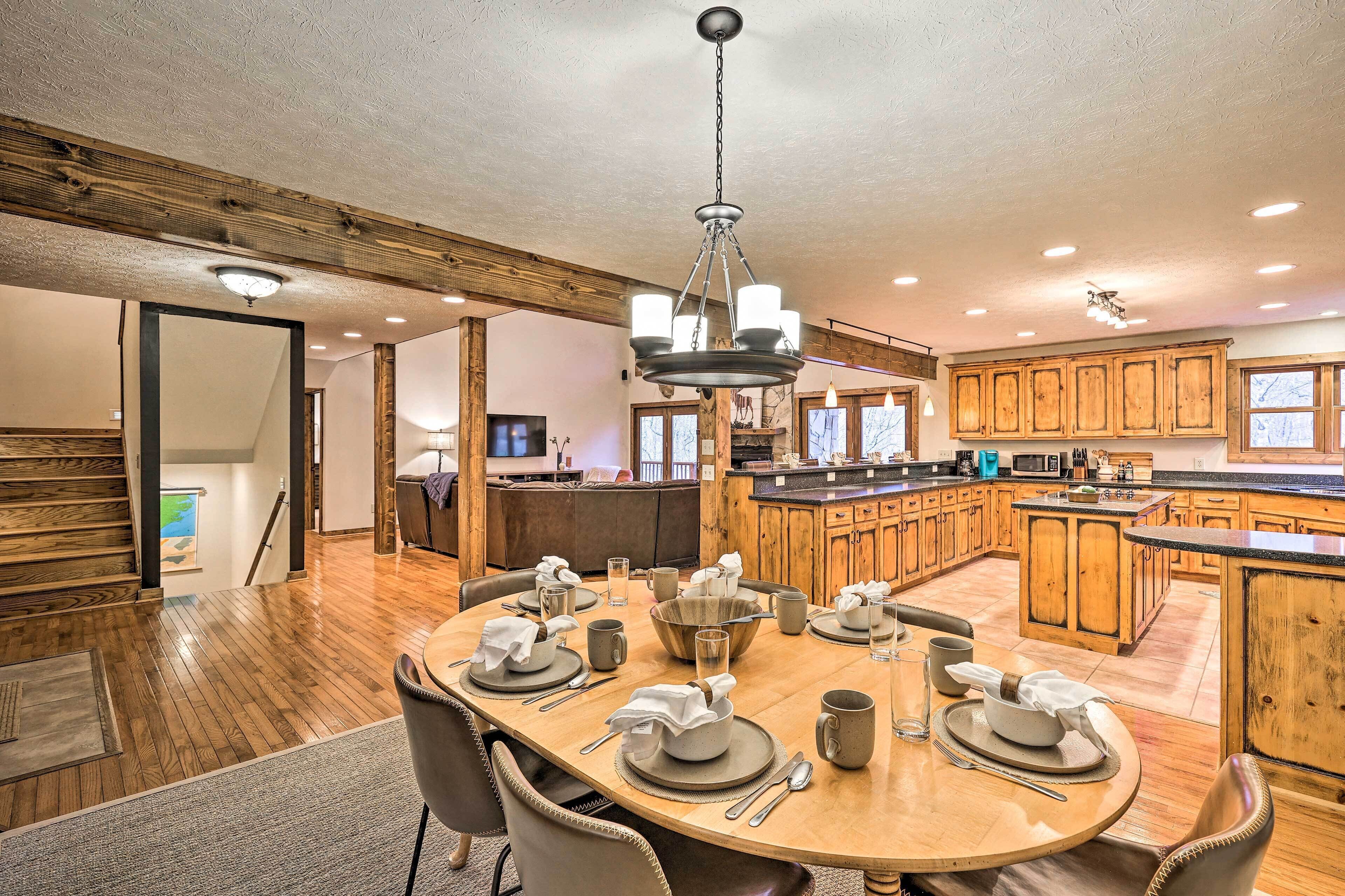 A spacious kitchen with wooden cabinets, a large island, and a dining area with a round table set for four.