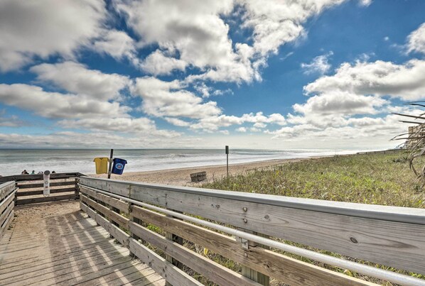 A wooden boardwalk leading to a beach with a clear sky and clouds. - Coastal Bungalow 2 Blocks to Ormond Beach! (Ormond Beach)