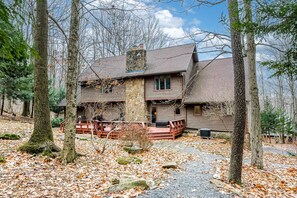 A rustic cabin with a stone chimney, wooden deck, and a gravel driveway surrounded by trees. - Family-friendly Terra Alta Home w/ Lake View! (Terra Alta)