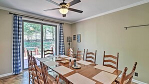 A dining area with a wooden table, chairs, and a ceiling fan.