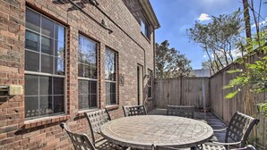 A brick house with a patio table and chairs, a wooden fence, and a clear sky. - Spacious Home w/ Patio: 5 Mi to Memorial Park (Houston)