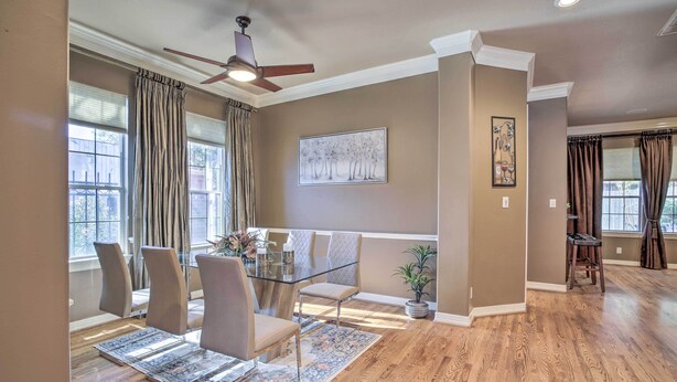 A dining area with a glass table, cushioned chairs, a patterned rug, and a ceiling fan. - Spacious Home w/ Patio: 5 Mi to Memorial Park (Houston)