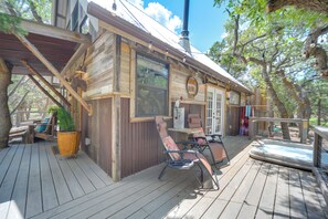 Eine Holzhütte mit einer Terrasse, zwei Schaukelstühlen und einem Whirlpool.