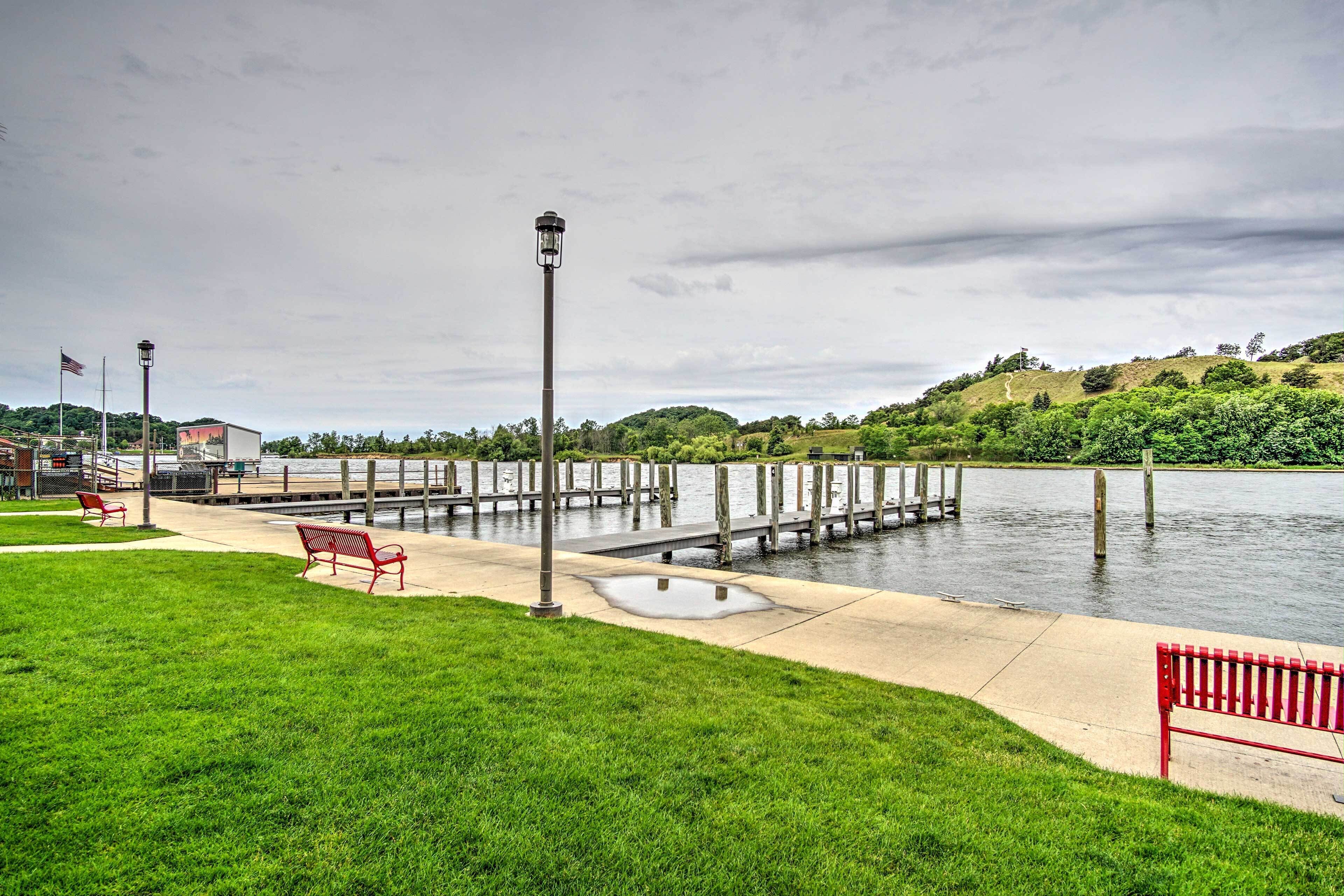 Un parc au bord de l’eau, doté d’un quai, de bancs et d’un lampadaire.