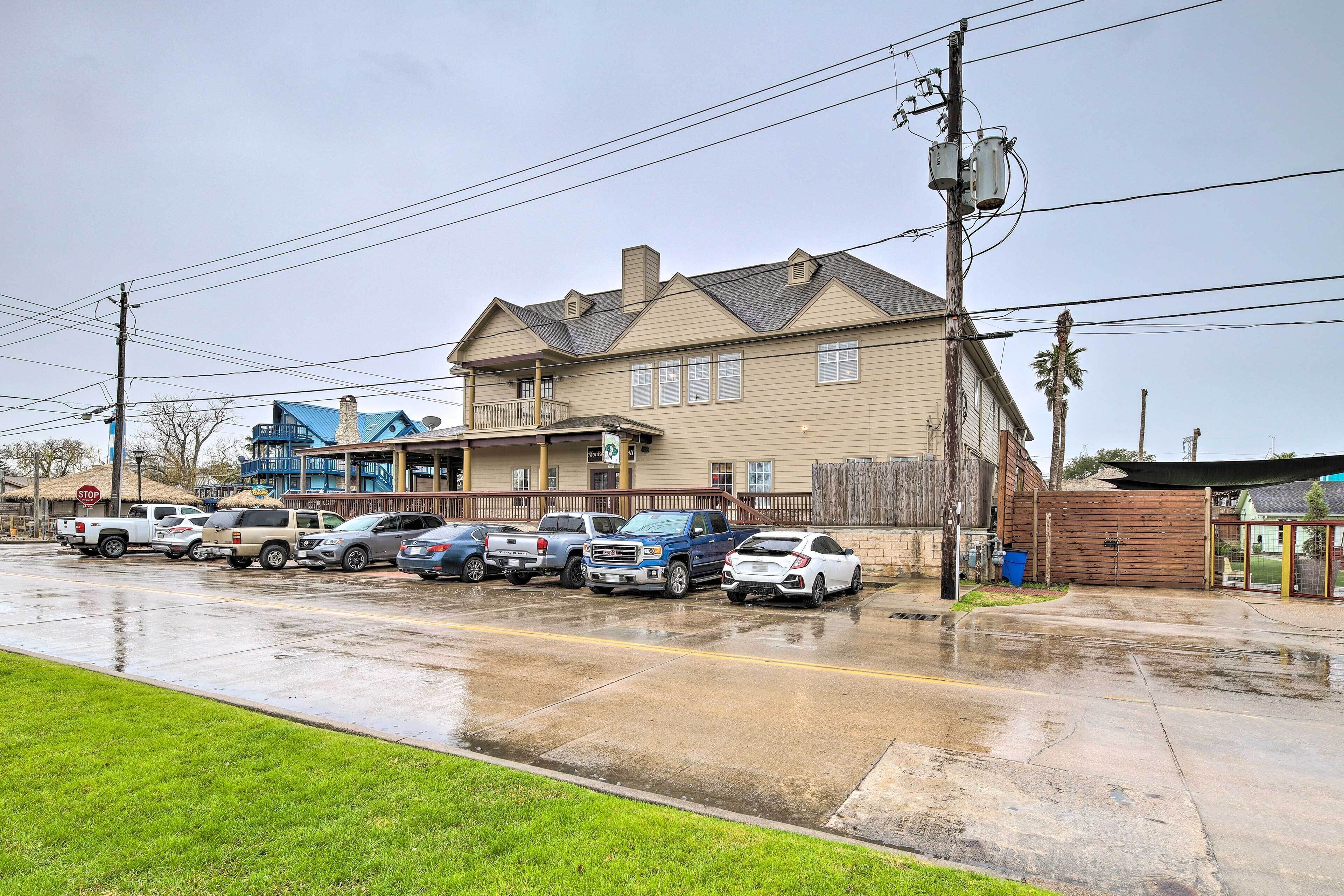 A parking lot with several cars parked in front of a building with a beige facade and a blue roof.