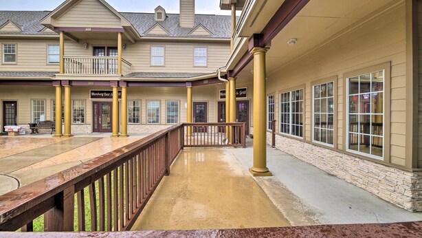A building with a covered patio area, columns, and a sign for 'Monkey Bar & Grill'. - Apt w/ Balconies - Steps to Kemah Boardwalk! (Kemah)