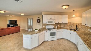 A modern kitchen with white cabinets, granite countertops, a built-in oven, and a microwave. - Apt w/ Balconies - Steps to Kemah Boardwalk! (Kemah)
