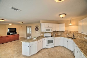 A modern kitchen with white cabinets, granite countertops, a built-in oven, and a microwave. - Apt w/ Balconies - Steps to Kemah Boardwalk! (Kemah)