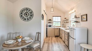 A kitchen with a white refrigerator, a microwave, and a sink. There is a dining table with chairs and a clock on the wall. - On-site Pond & Fire Pit: Montague Retreat! (Montague)