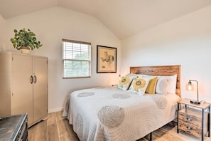 A bedroom with a bed, a nightstand, a lamp, a potted plant, a wardrobe, and a window with blinds. - On-site Pond & Fire Pit: Montague Retreat! (Montague)