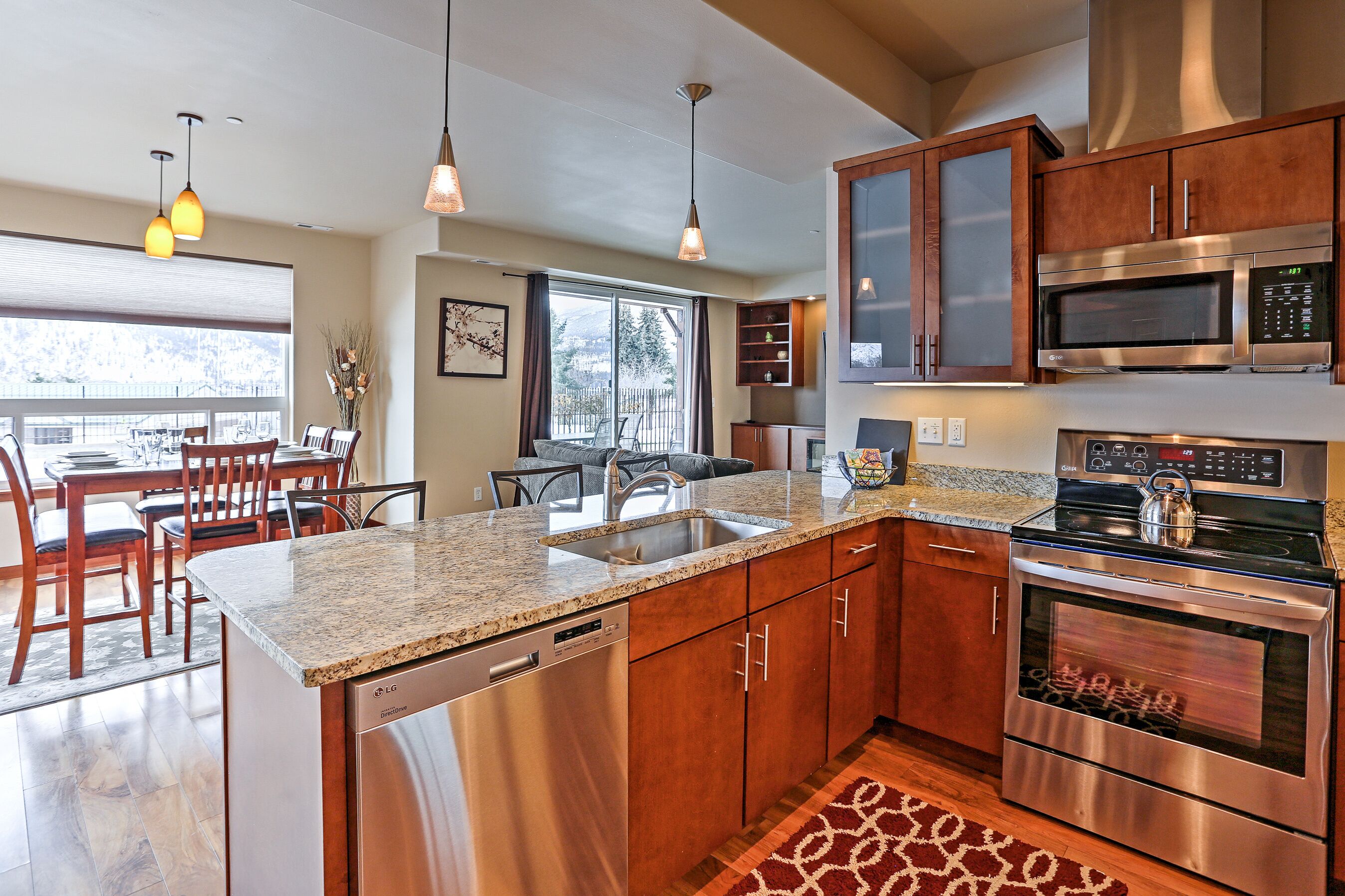 A modern kitchen with granite countertops, stainless steel appliances, and wooden cabinets.