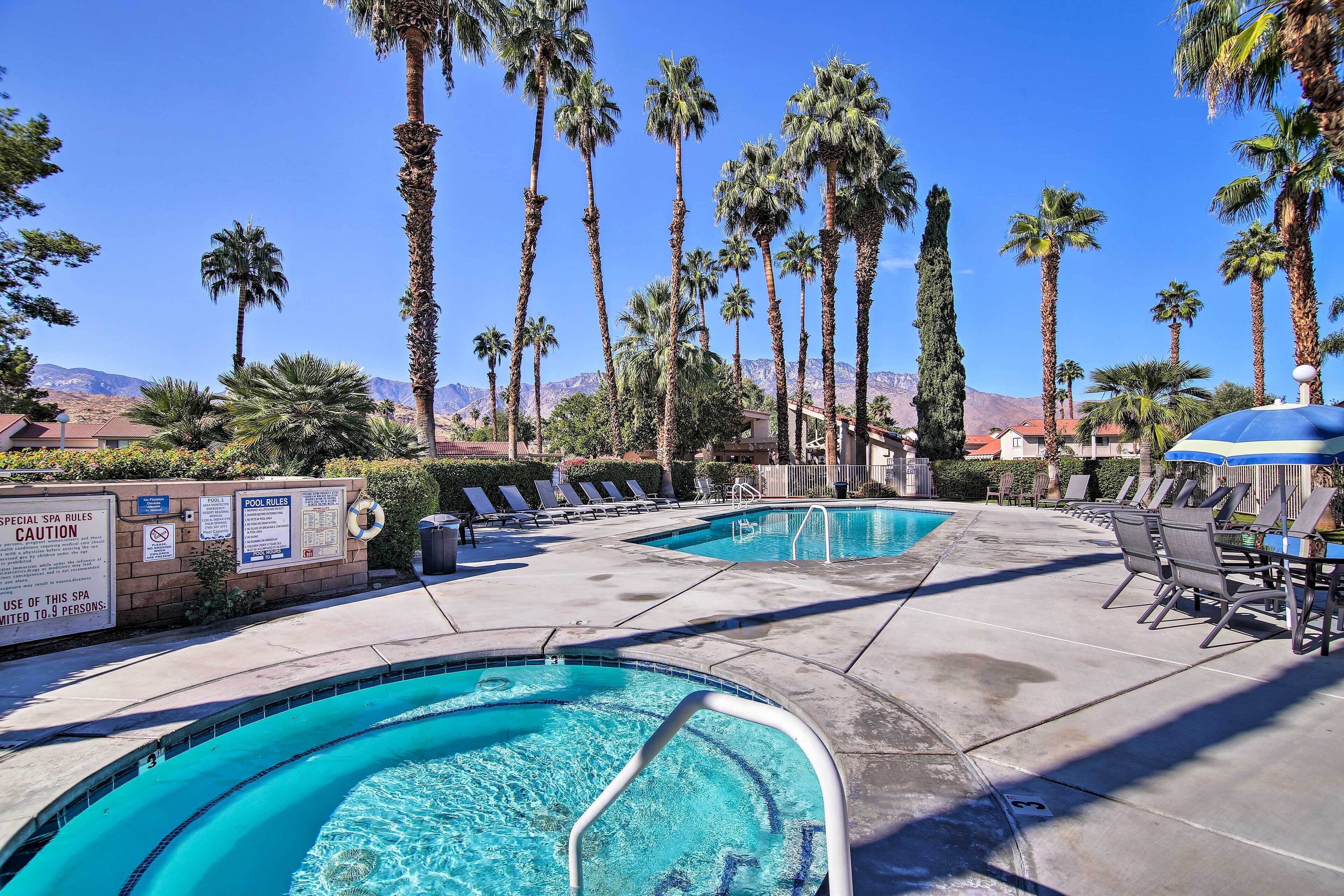 A pool area with two pools, lounge chairs, and palm trees.