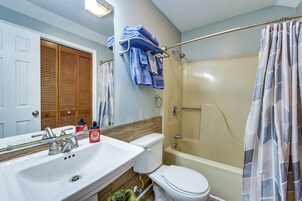 Un baño con lavamanos, inodoro y bañera.
