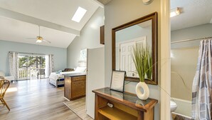 A spacious room with a large bed, a desk, and a bathroom with a shower curtain. - 4 Mi to Cherry Grove Beach: Studio w/ Pool Access (Little River)