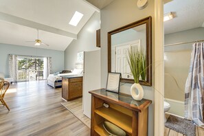 A spacious room with a large bed, a desk, and a bathroom with a shower curtain. - 4 Mi to Cherry Grove Beach: Studio w/ Pool Access (Little River)