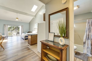 A spacious room with a large bed, a desk, and a bathroom with a shower curtain.