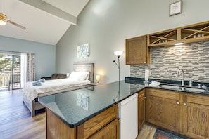 A modern kitchen with a wooden countertop, a built-in sink, and a backsplash with a geometric pattern. - Cherry Grove Beach Studio w/ Heated Indoor Pool! (Little River)