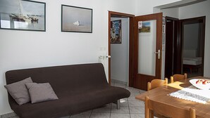 A room with a brown sofa, a wooden dining table with chairs, and two framed pictures on the wall. - APP1 Romantic villa with pool - 5 min from the beach! (Novigrad)
