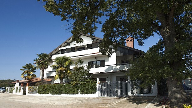 A two-story residential building with a white facade, a balcony on the upper floor, and a brick chimney. - APP1 Romantic villa with pool - 5 min from the beach! (Novigrad)