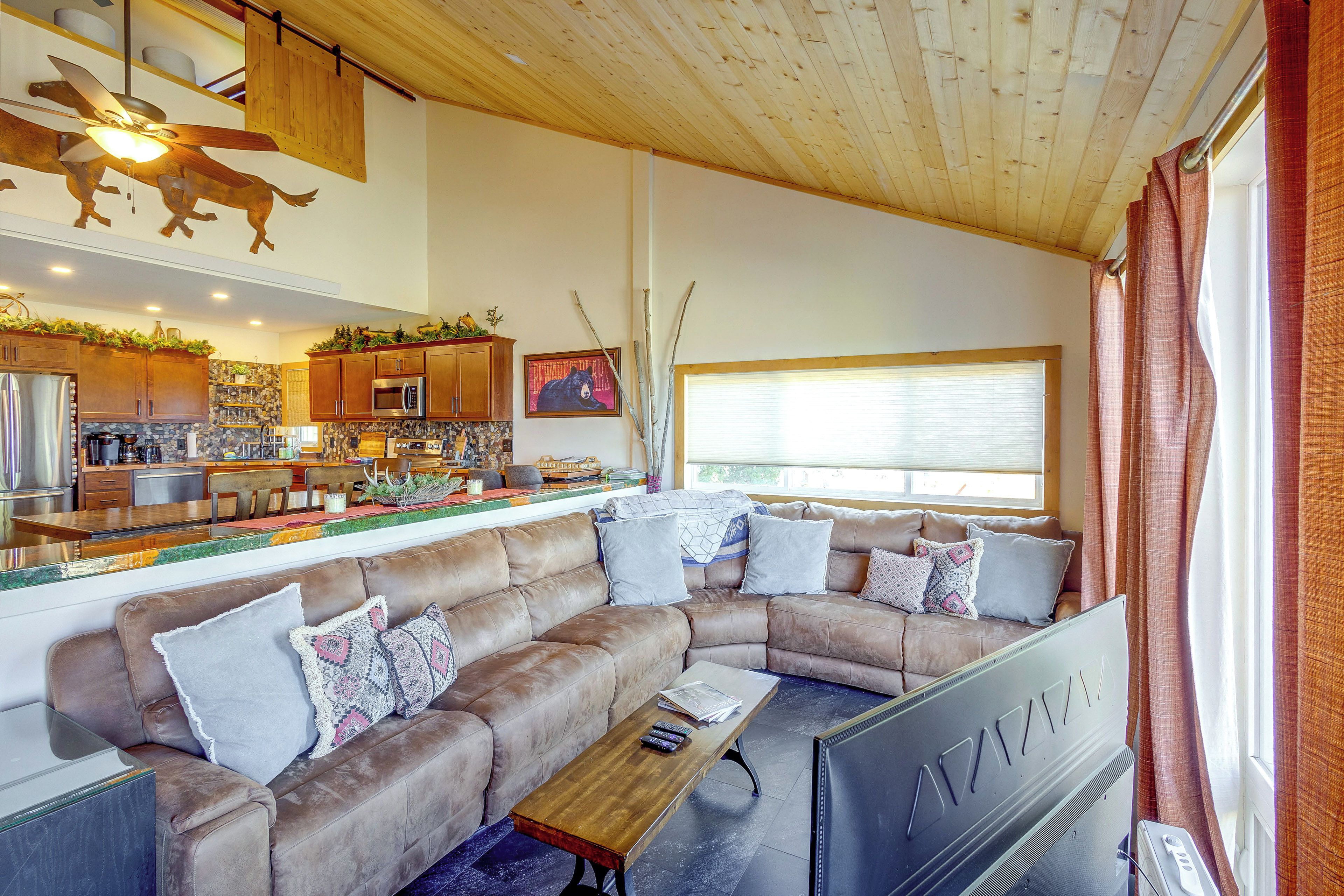 A modern living room with a sectional sofa, a coffee table, and a television.