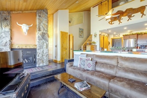A cozy living room with a fireplace, a stone accent wall, a wooden ceiling, and a leather sofa. - Ski, Soak & Explore! Granby Getaway w/ Mtn Views (Granby)