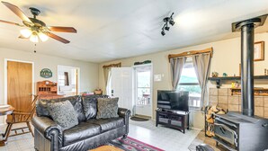 Ein Wohnzimmer mit Ledersofa, Fernseher, Kamin und Deckenventilator.