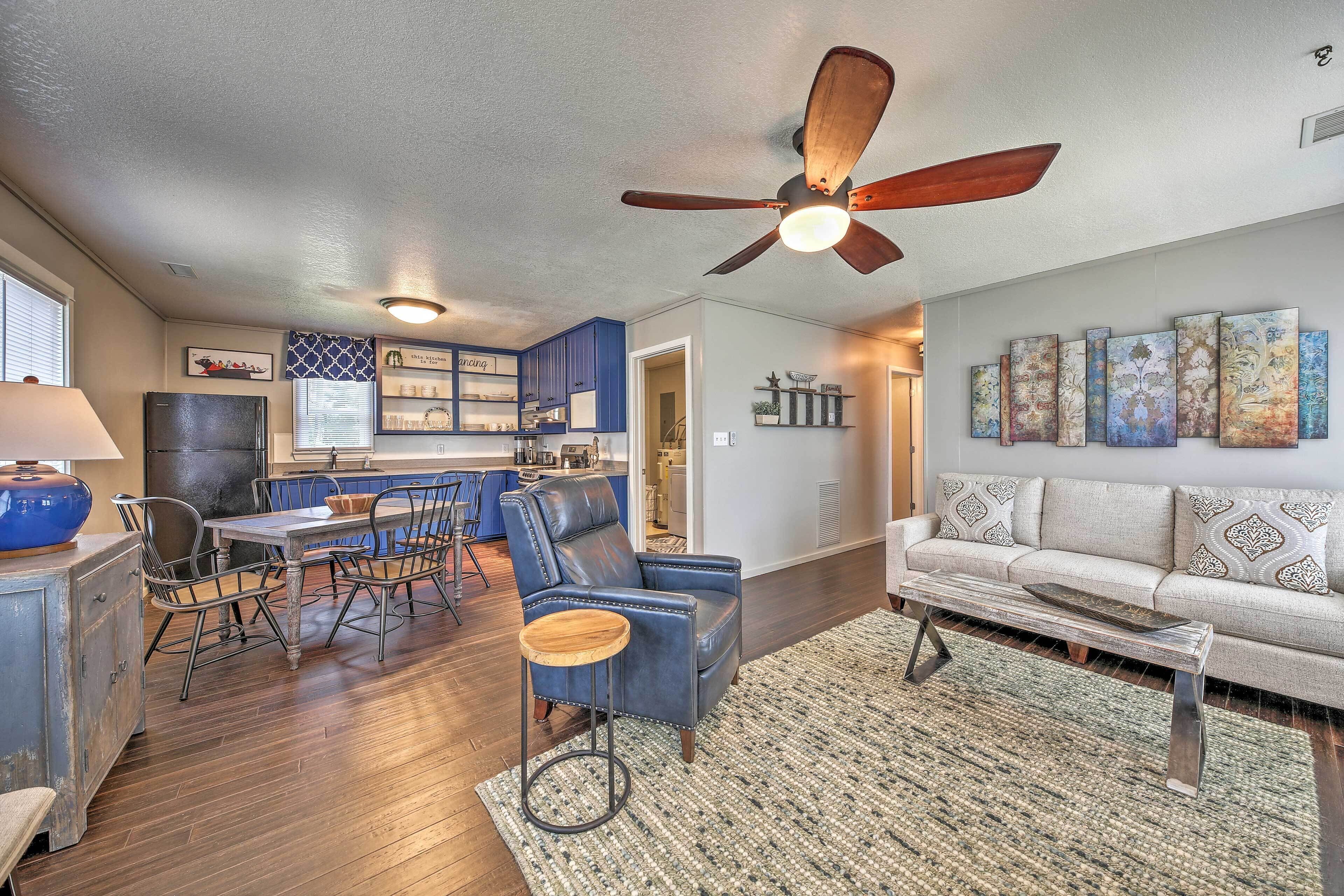 A spacious living room with a sofa, a coffee table, and a dining area with chairs and a table.