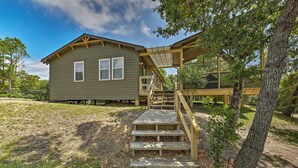 A house with a wooden deck and a staircase leading to a covered porch. - Cozy Cottage < 2 Mi to Cape Hatteras Natl Shore! (Frisco)