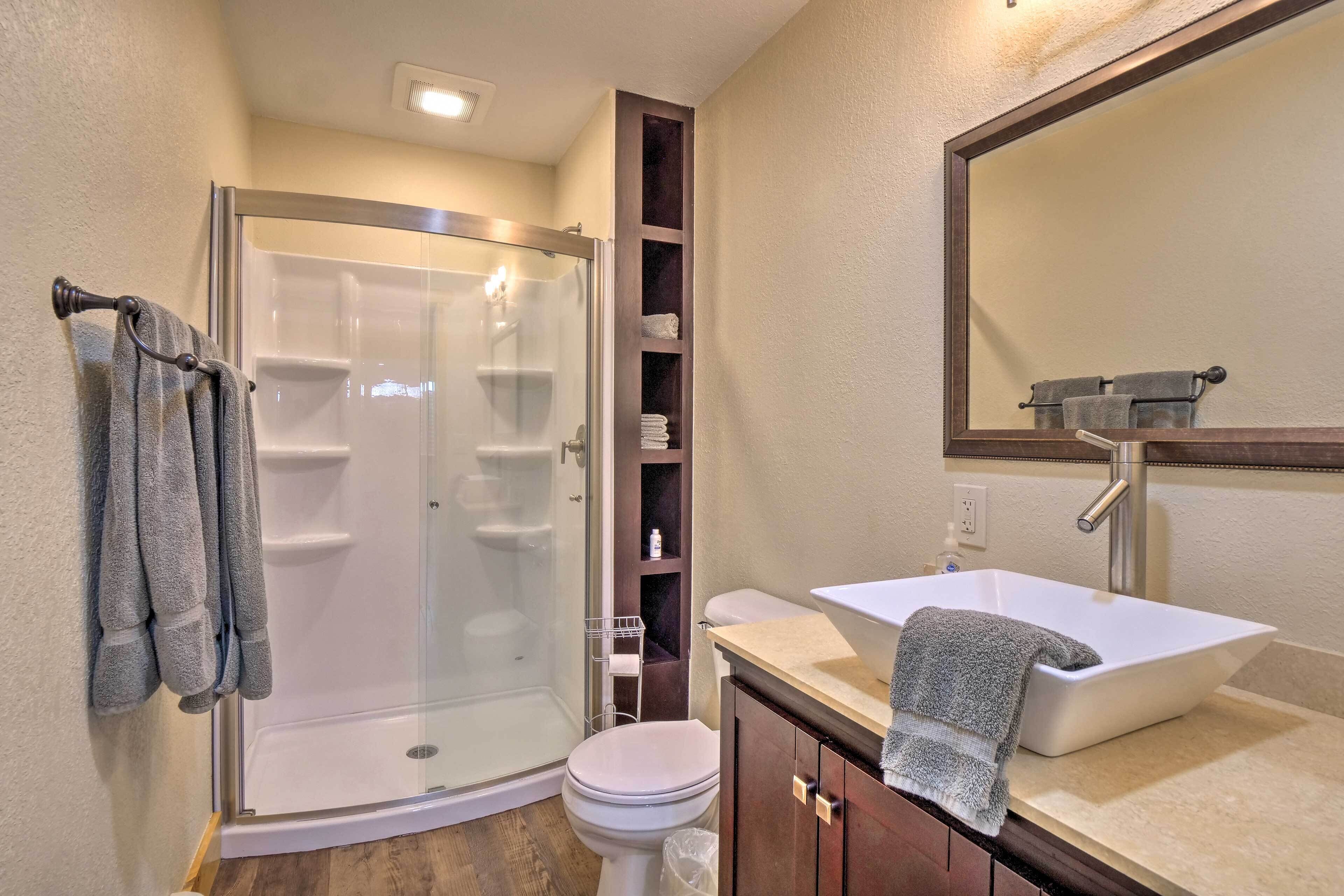 Une salle de bain avec une douche à parois de verre, un lavabo blanc et des toilettes.