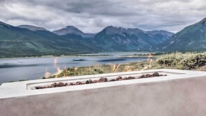 Une vue d’un lac entouré de montagnes, avec une corniche en béton au premier plan.