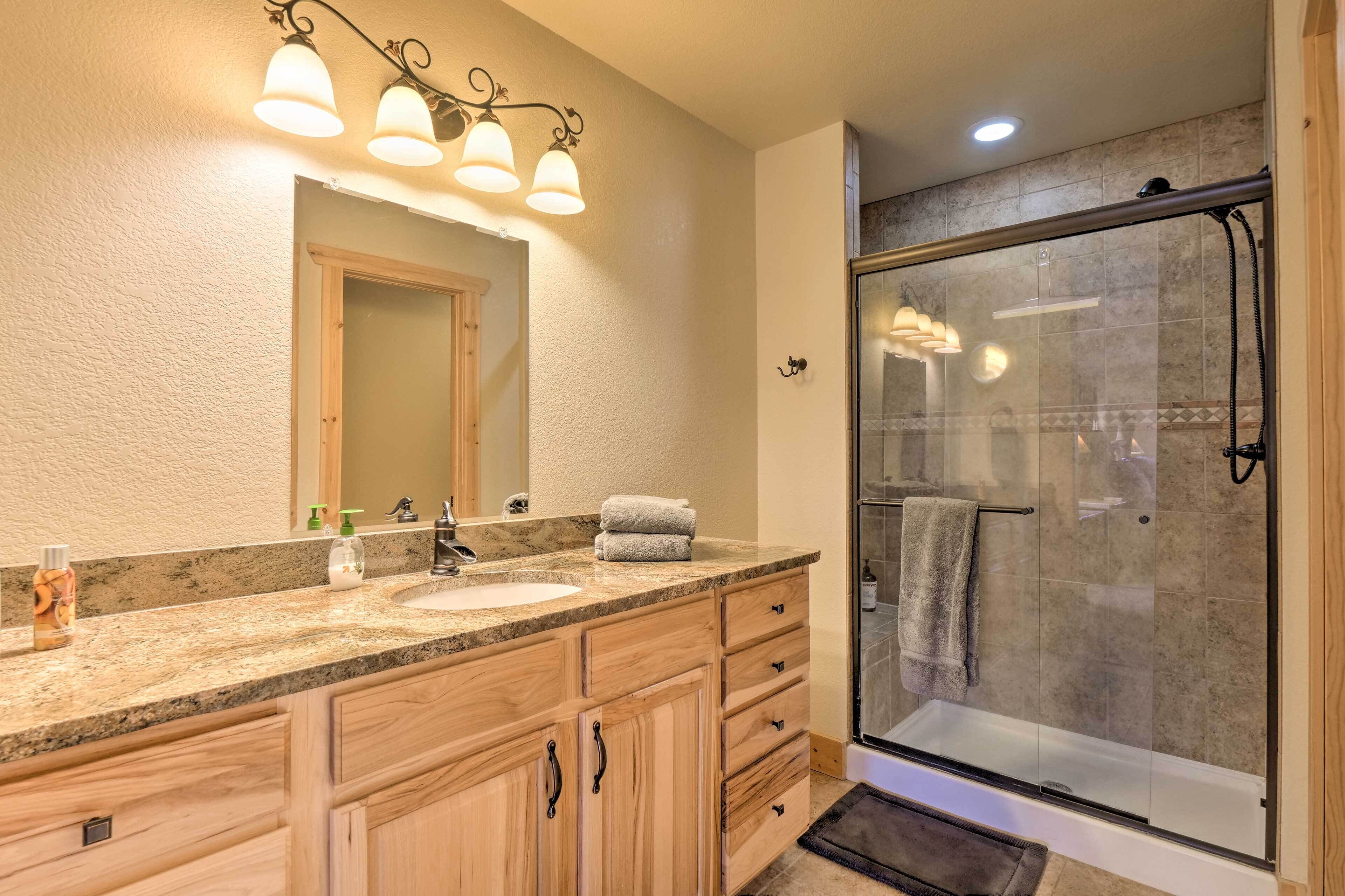 A bathroom with a double sink vanity, a large mirror, and a glass-enclosed shower.