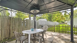 An outdoor patio with a round table and chairs, a metal lamp, and a wooden fence. - Geneva-on-the-lake Cottage w/ Patio: Walk to Shore (Geneva)