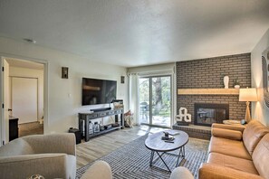 A modern living room with a fireplace, a flat-screen TV, and a comfortable seating area. - Stunning Condo By Trails, Nat'l Monument! (Grand Junction)